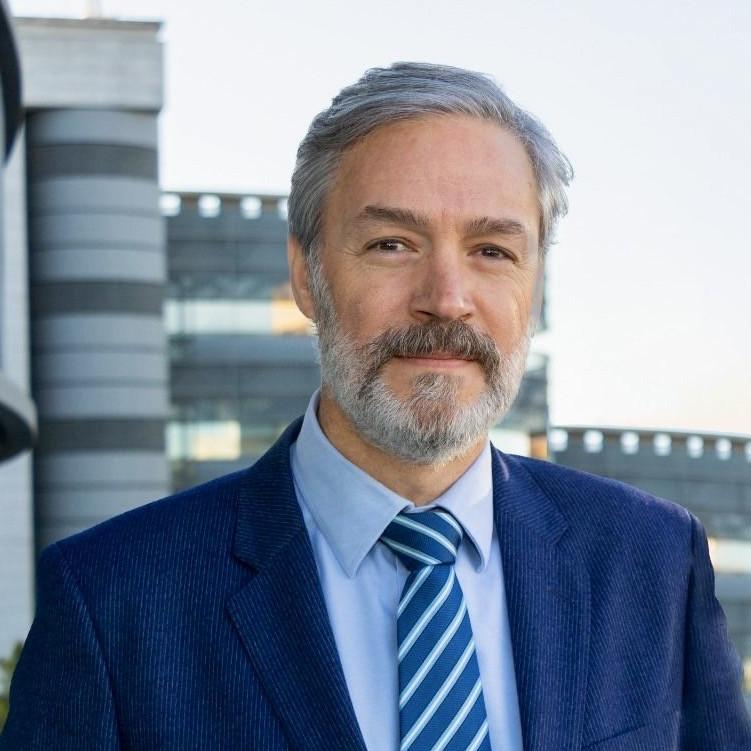 Retrato de Agustín Canales, director de Healthcare de Grupo Lantero, con traje azul frente a un edificio corporativo.